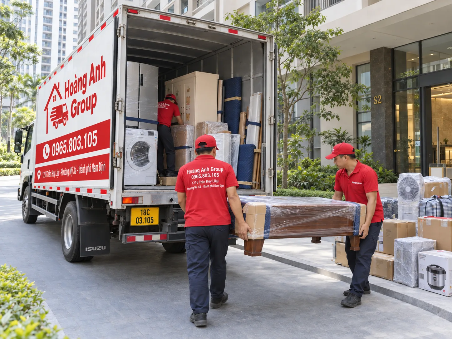Xe tải thùng kín Hoàng Anh Group và nhân viên áo đỏ chuyển đồ tại điểm giao nhận